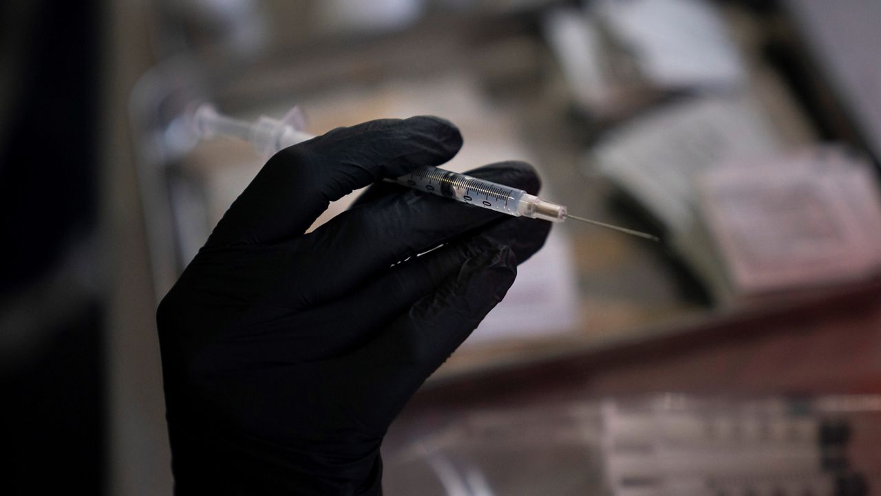 In this Aug. 28, 2021, file photo, pharmacy intern Jasmine Hana holds a syringe with the COVID-19 vaccine at a vaccine clinic set up in the parking lot of CalOptima in Orange, Calif. (AP Photo/Jae C. Hong)