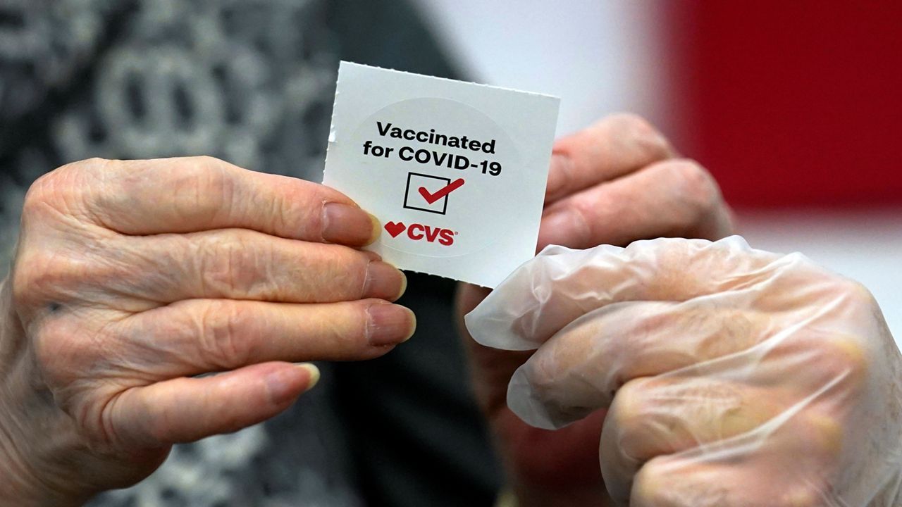 In this March 1, 2021, file photo, a patient receives a sticker after getting a shot of the Moderna COVID-19 at a CVS Pharmacy branch in Los Angeles.  (AP Photo/Marcio Jose Sanchez)