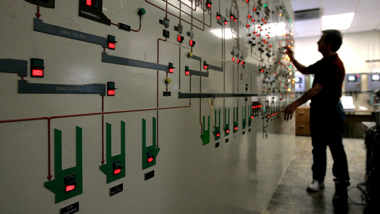 Glowing red lights indicate those machines shut down to conserve energy as control room supervisor Joe Samuels shuts down additional machines at the Farmers Rice Cooperative in West Sacramento, Calif. on Aug. 30, 2007. (AP Photo/Rich Pedroncelli)