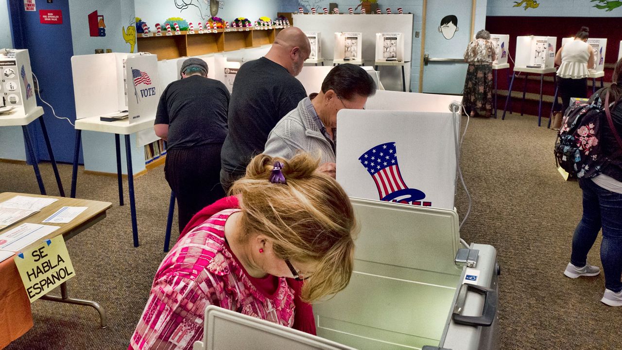 In this June 5, 2018, file photo, voters mark ballots at a polling place in the library at the Robert F. Kennedy Elementary School in Los Angeles.  (AP Photo/Richard Vogel)