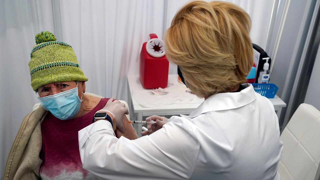 In this March 1, 2021, file photo, Estela Perales, left, gets a shot of the Moderna COVID-19 vaccine from pharmacy technician Ani Stepanian at a CVS Pharmacy branch in Los Angeles. (AP Photo/Marcio Jose Sanchez)