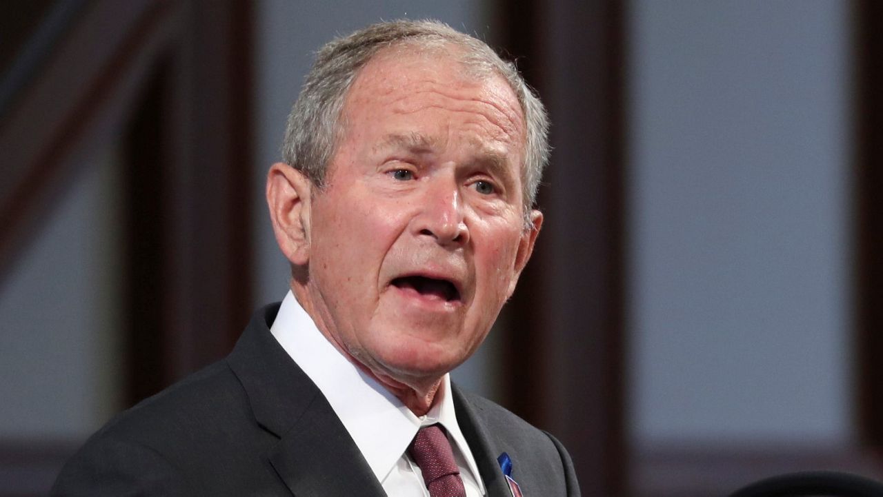 In this May 7, 2021, file photo, former President George W. Bush listens to speakers during the opening ceremony of the Walker Cup golf tournament. (AP Photo/Gerald Herbert)