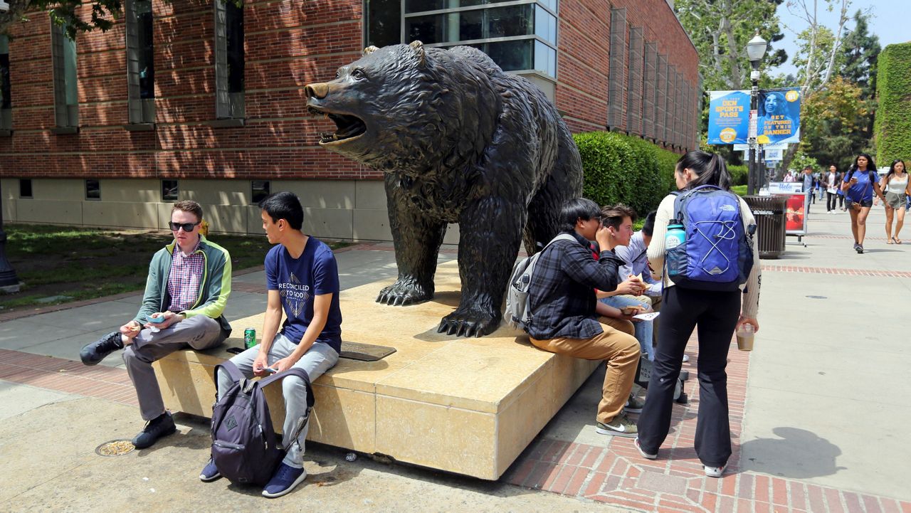 In this April 26, 2019, file photo, people move about the University of California, Los Angeles. (AP Photo/Reed Saxon)