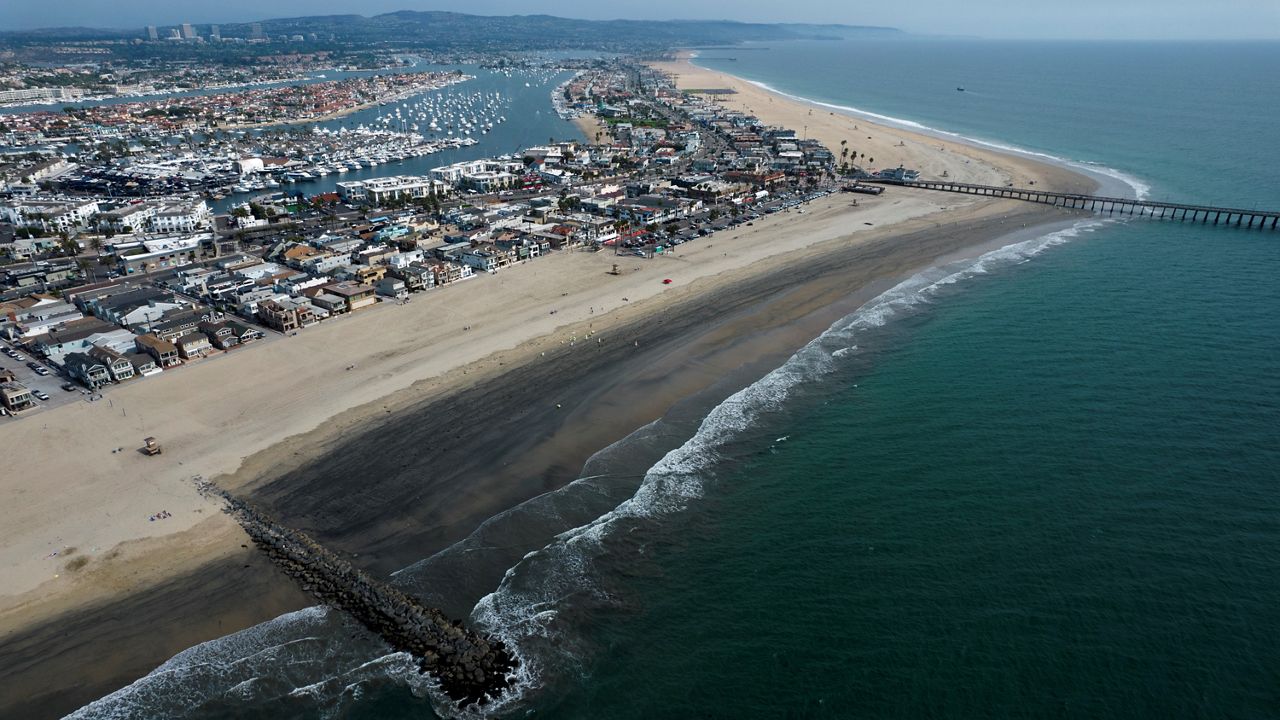 An aerial photo shows the closed beach after oil washed up on a beach on Oct. 6, 2021, in Newport Beach, Calif. The oil is said to have reached as far south as Laguna Beach. (AP Photo/Ringo H.W. Chiu)