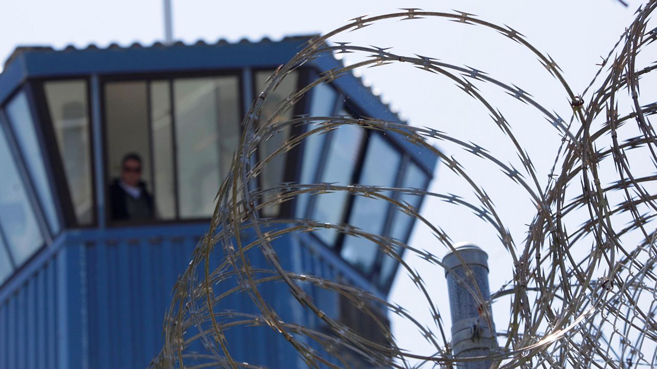 In this Aug. 17, 2011, file photo, concertina wire and a guard tower are seen at Pelican Bay State Prison near Crescent City, Calif. (AP Photo/Rich Pedroncelli) 