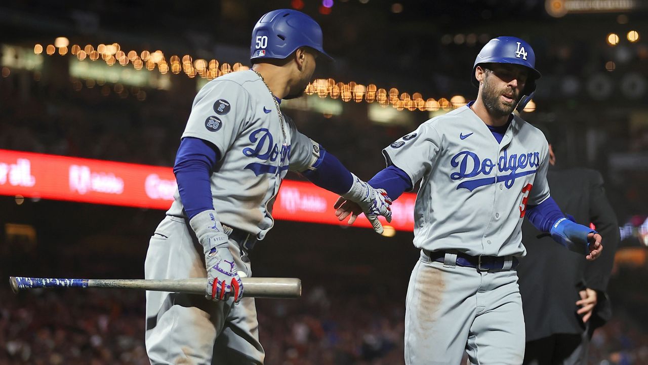 Los Angeles Dodgers' Chris Taylor, right, is congratulated by Mookie Betts after scoring against the San Francisco Giants Saturday during the eighth inning of Game 2 of a baseball National League Division Series in San Francisco. (AP Photo/John Hefti)