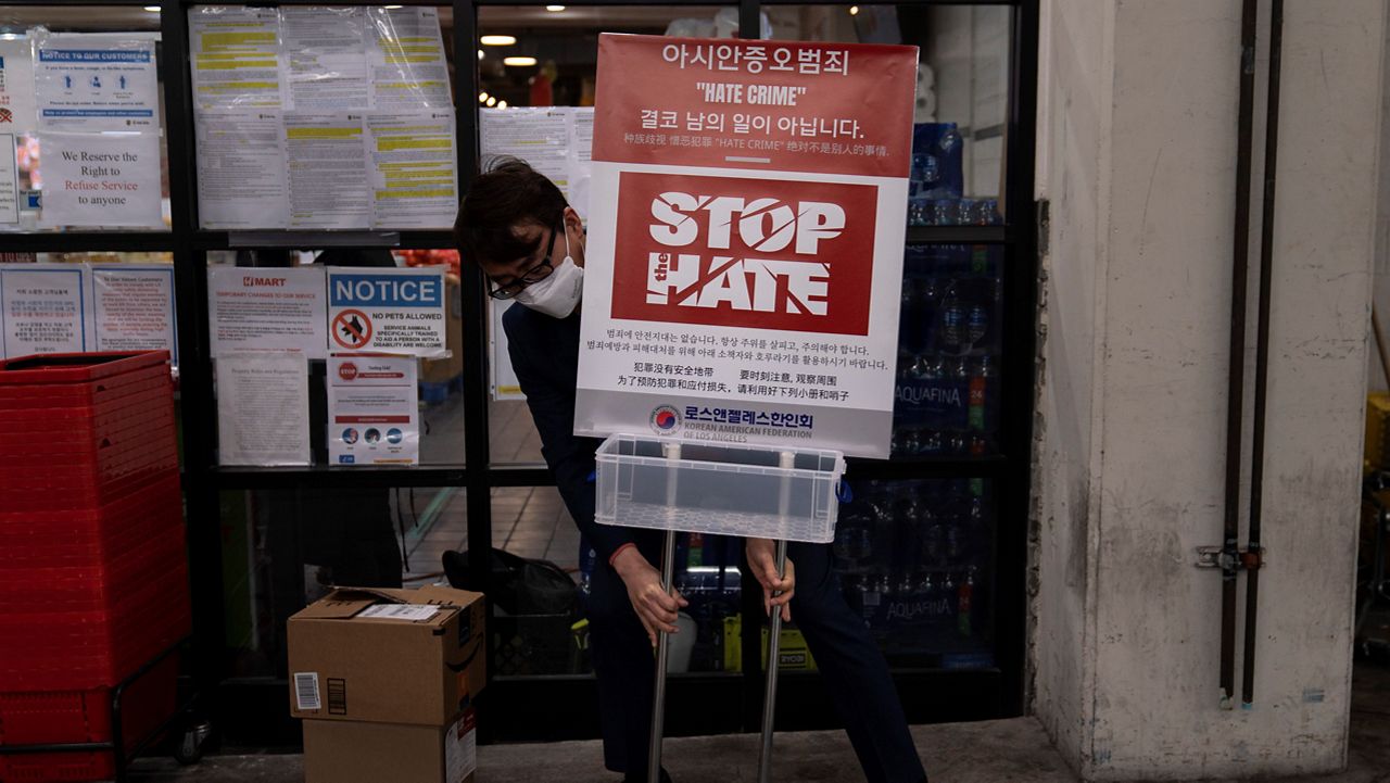 In this March 23, 2021, file photo, Peter Chang from the Korean American Federation of Los Angeles places a poster to bring awareness to anti-Asian hate crimes in the Koreatown neighborhood of Los Angeles. (AP Photo/Jae C. Hong)