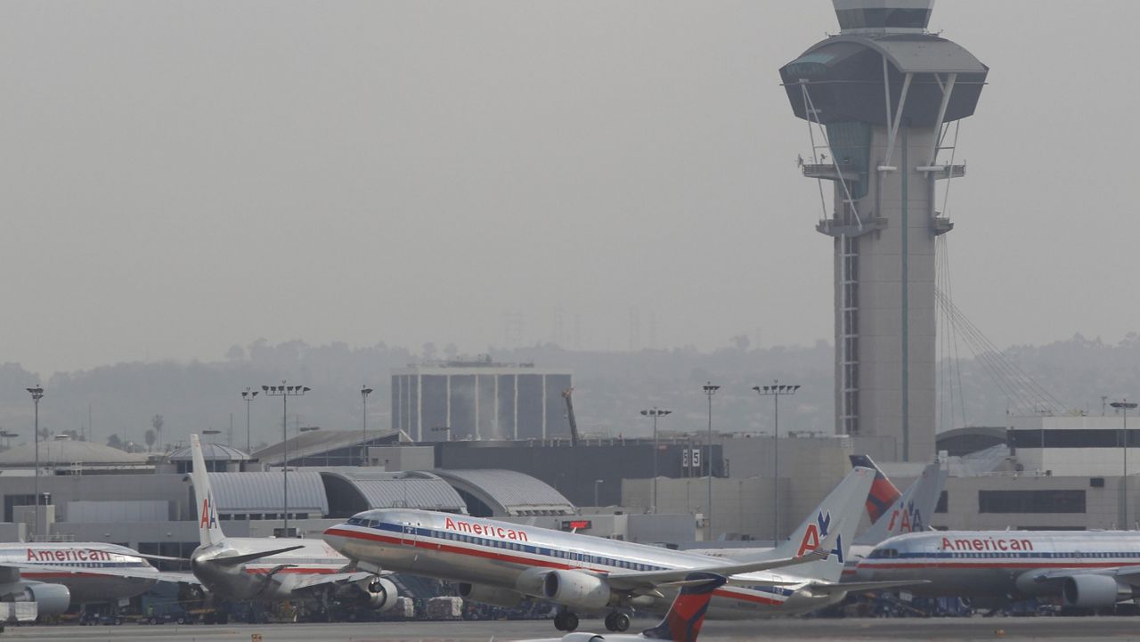 This April 22, 2013, file photo shows an American Airlines plane taking off at LAX International airport in Los Angeles. (AP Photo/Damian Dovarganes)