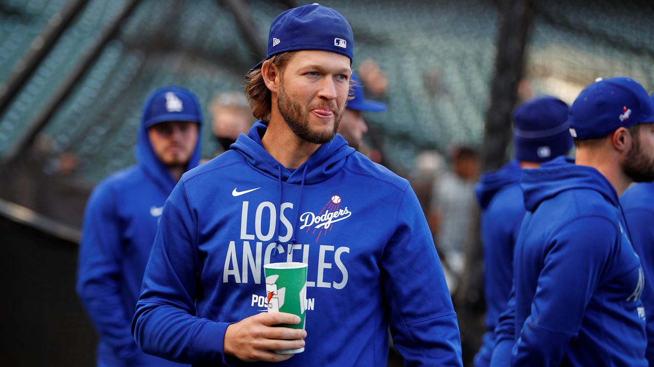 Injured LA Dodgers pitcher Clayton Kershaw watches as players warm up before Game 1 of a baseball National League Division Series against the San Francisco Giants in San Francisco., Oct. 8, 2021. (AP Photo/John Hefti)