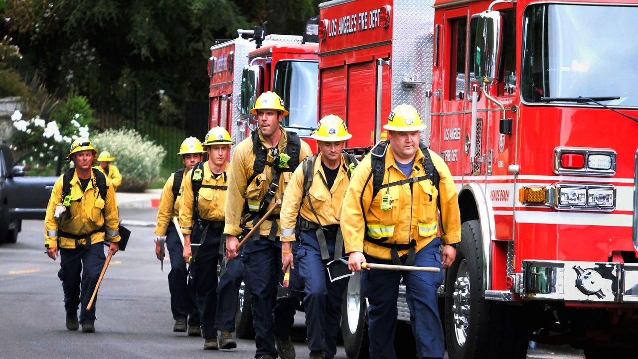 In this May 16, 2021, file photo, firefighters walk in line to fight the wildfire in the Pacific Palisades area of Los Angeles. (AP Photo/Ringo H.W. Chiu)