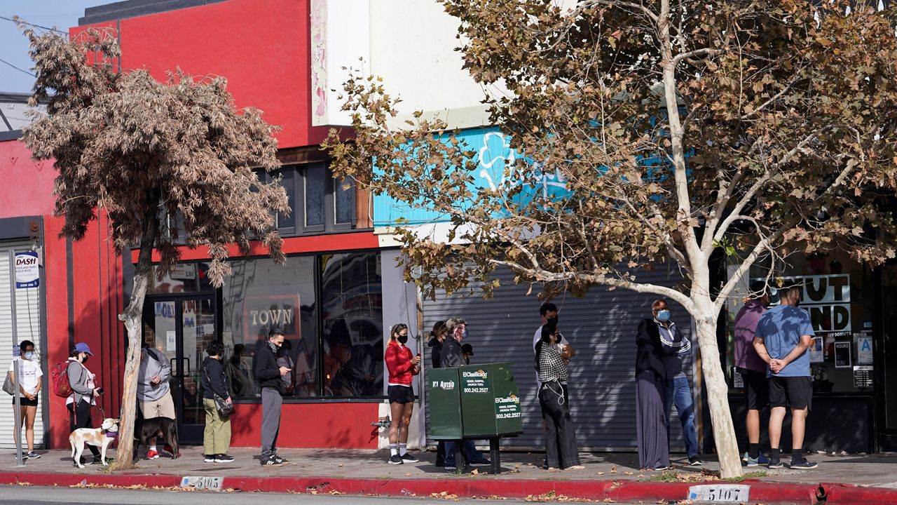 Patrons keep their social distance while waiting for donuts outside Donut Friend bakery in the Highland Park neighborhood of Los Angeles on Nov. 6, 2021. (AP Photo/Damian Dovarganes)