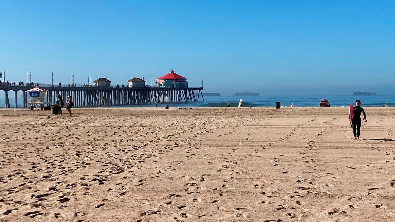 In this Oct. 10, 2021, file photo, surfers leave the water after lifeguards enforce the closure of the ocean in Huntington Beach, Calif. (AP Photo/Amy Taxin)