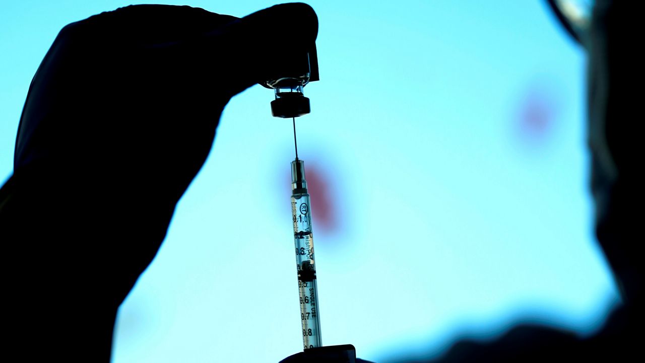 A health care worker prepares a syringe with the Pfizer COVID-19 vaccine. (AP Photo, File)