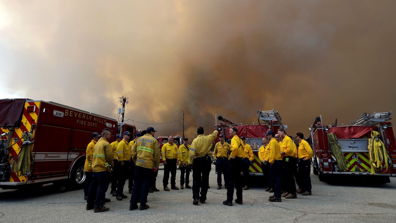 In this July 26, 2018, file photo, firefighters from the Beverly Hills Fire Department stage along highway 74 in Mountain Center, Calif. (AP Photo/Marcio Jose Sanchez)