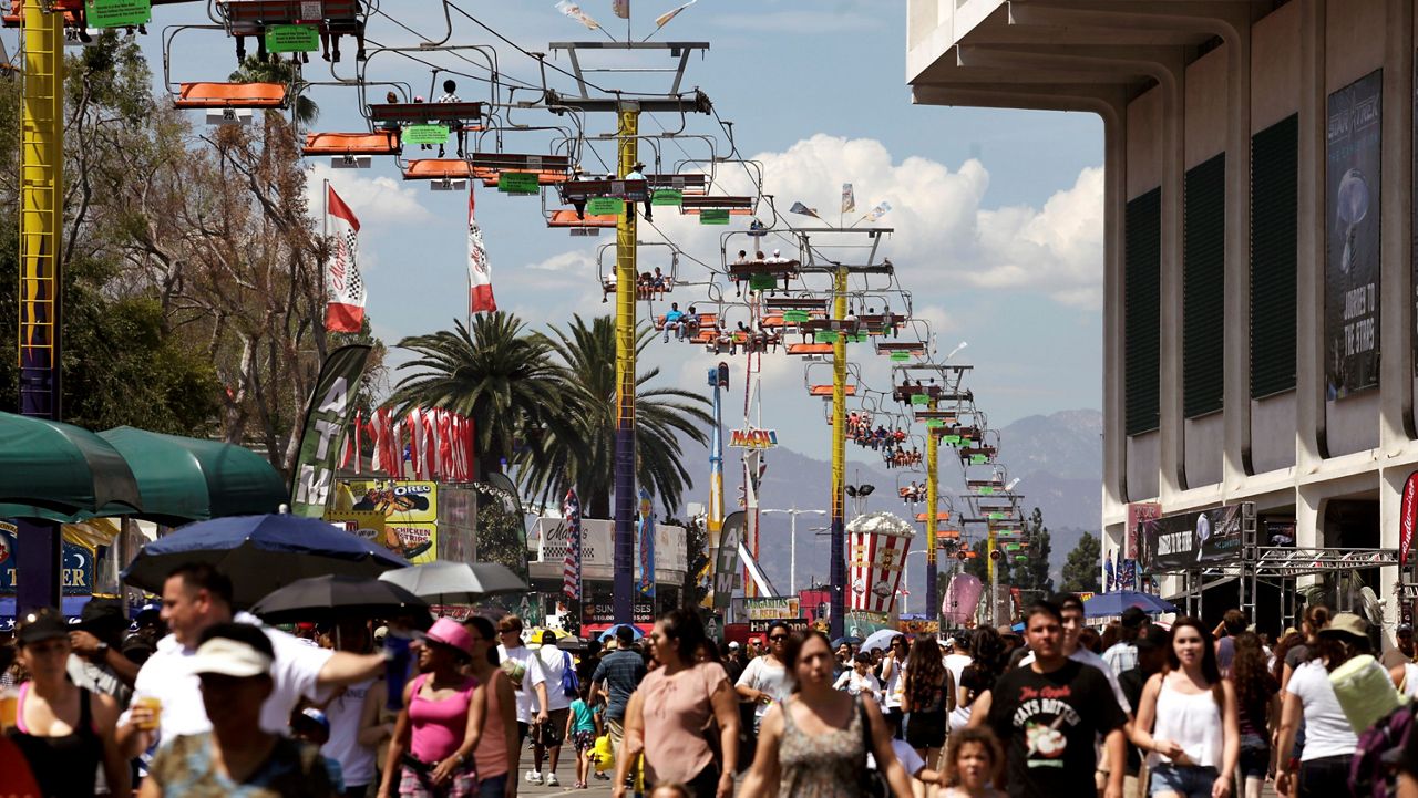 Fairgoers ride a tram over the crowds at the LA County Fair celebrating Labor Day in Pomona Calif. on Monday Sept. 2, 2013. (AP Photo/Richard Vogel)