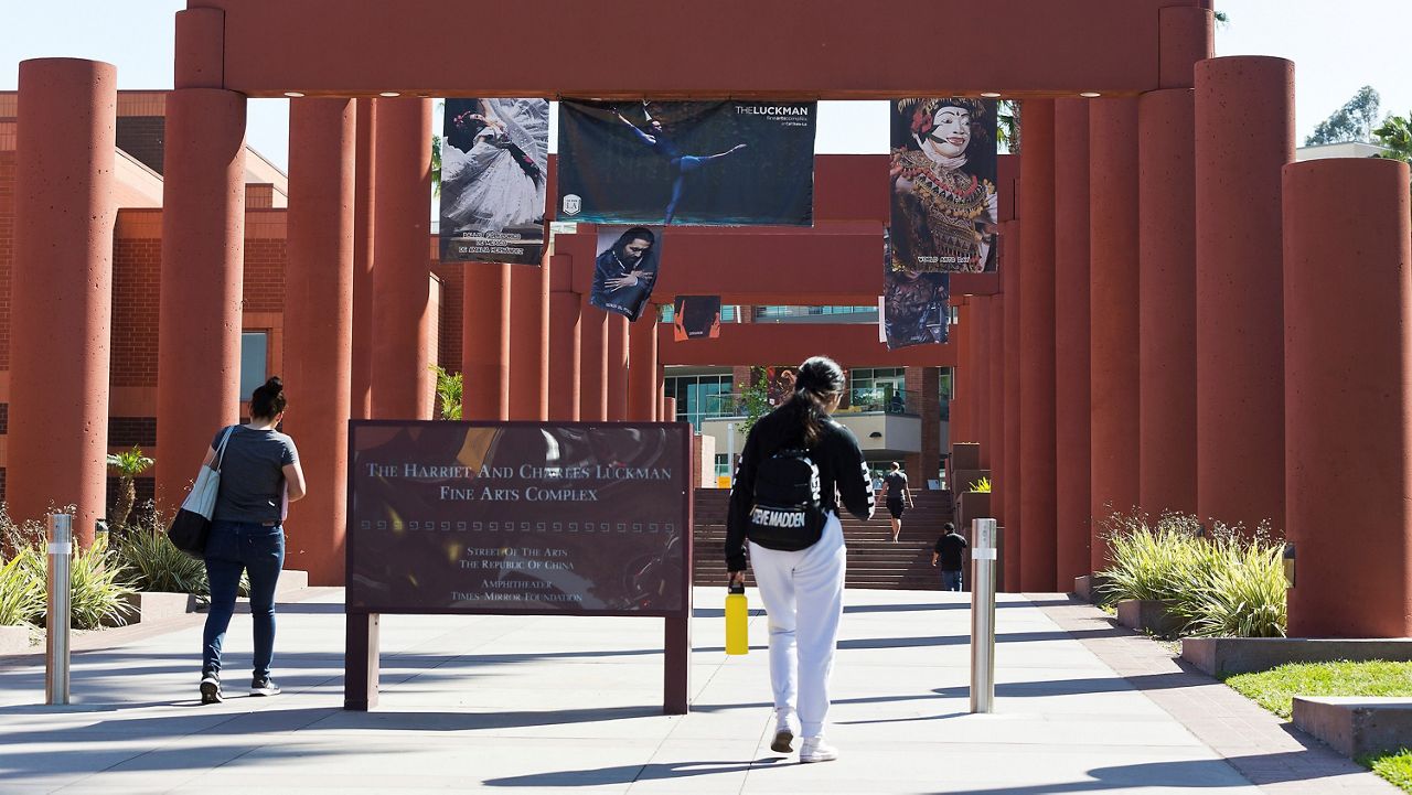 In this April 25, 2019, photo students walk past the Harriet and Charles Luckman Fine Arts Complex at the Cal State University, Los Angeles campus. (AP Photo/Damian Dovarganes, File)