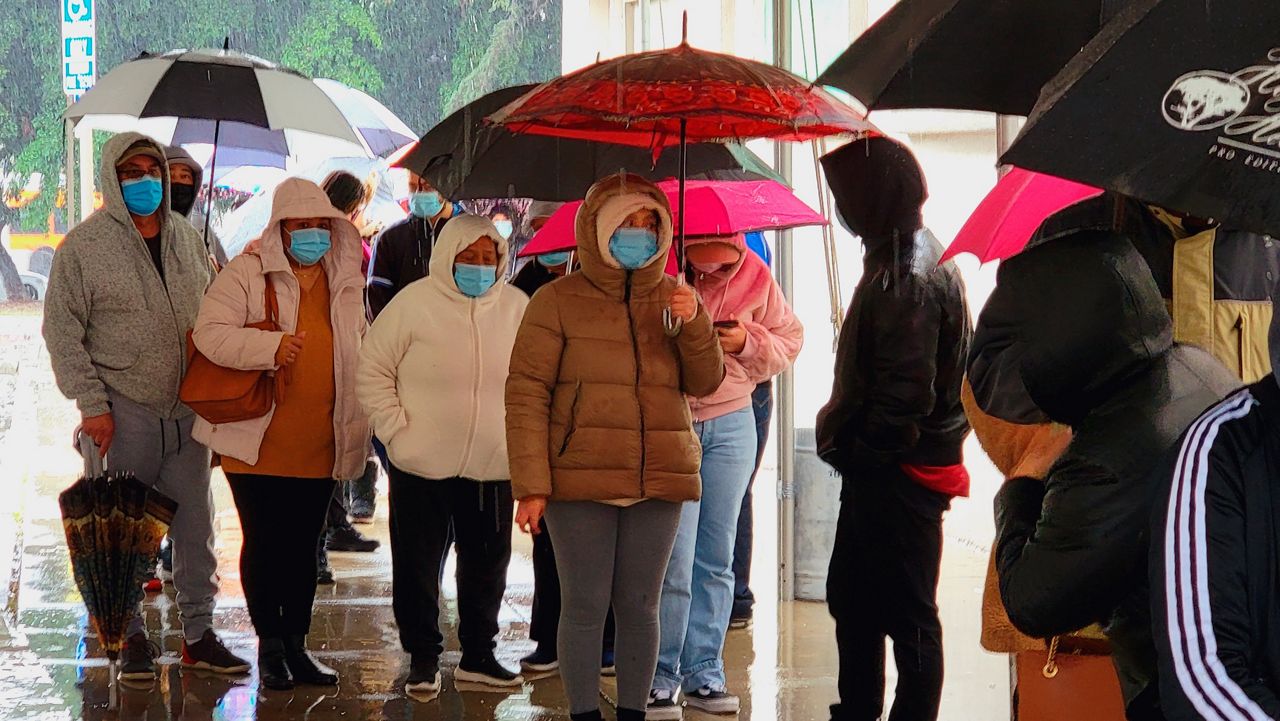 People wear face masks as they stand in line Thursday for a free COVID-19 test outside the Lincoln Park Recreation Center in Los Angeles. (AP Photo/Damian Dovarganes)