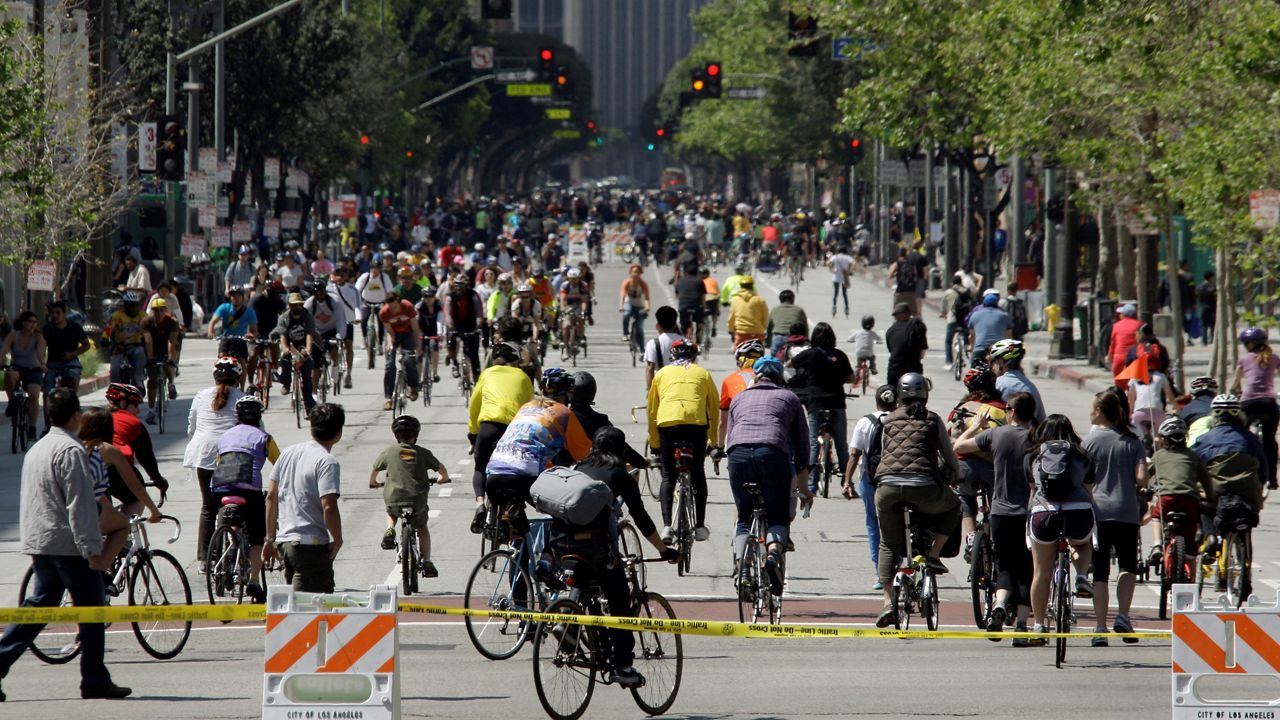 In this April 10, 2011, file photo, several blocks of Spring Street in downtown are swarming with people, not cars, during an event known as CicLAvia, where several miles of streets in Los Angeles are closed to all motor vehicle traffic and reserved for the use of bicyclists and pedestrians. (AP Photo/Reed Saxon)