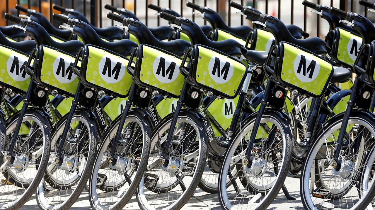 In this June 7, 2016, file photo, rows of bikes ready to be shared are lined up in Grand Park near Los Angeles City Hall. (AP Photo/Nick Ut)