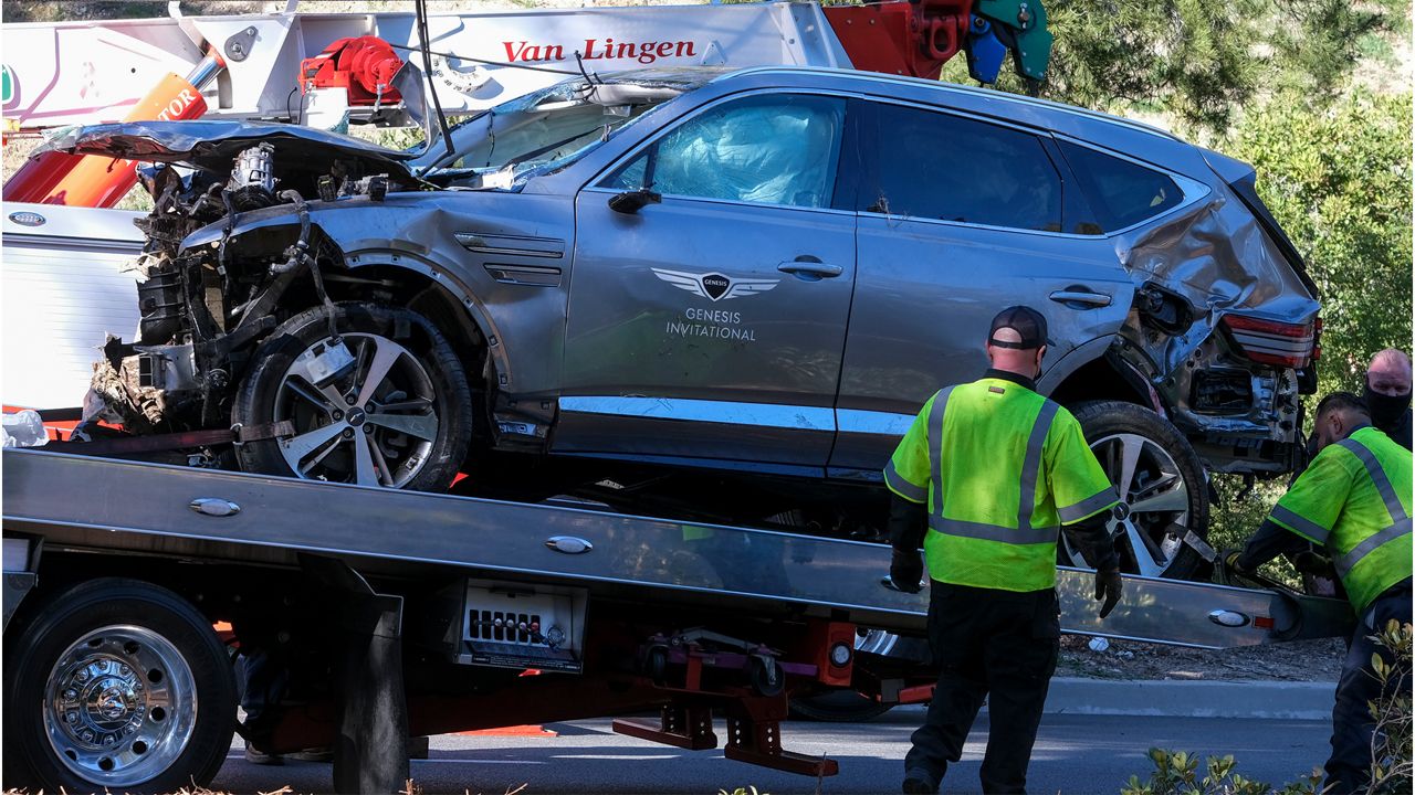 A damaged car is loaded onto another vehicle to be removed in Rancho Palos Verdes, Calif., Tuesday, Feb. 23, 2021. (AP Photo/Ringo H.W. Chiu)