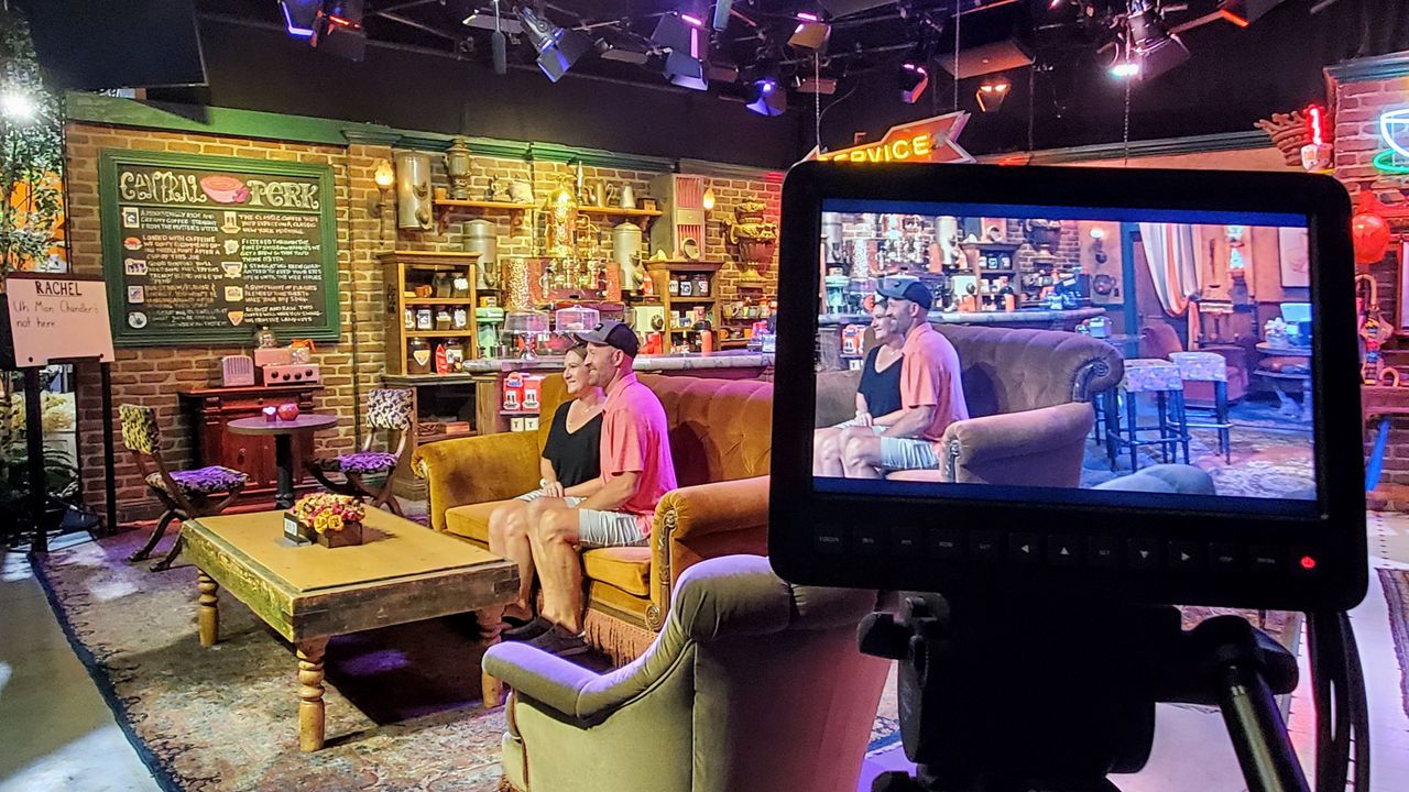 A couple takes a photo inside the Central Perk set of "Friends" during a Warner Bros. studio tour. (Spectrum News/Joseph Pimentel)