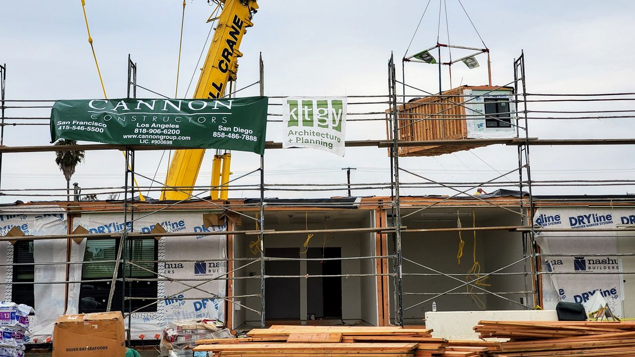 A crane lowers a modular wood unit at Casa Paloma, a modular wood constructed affordable and supportive housing community in Midway City (Spectrum News/ Joseph Pimentel)