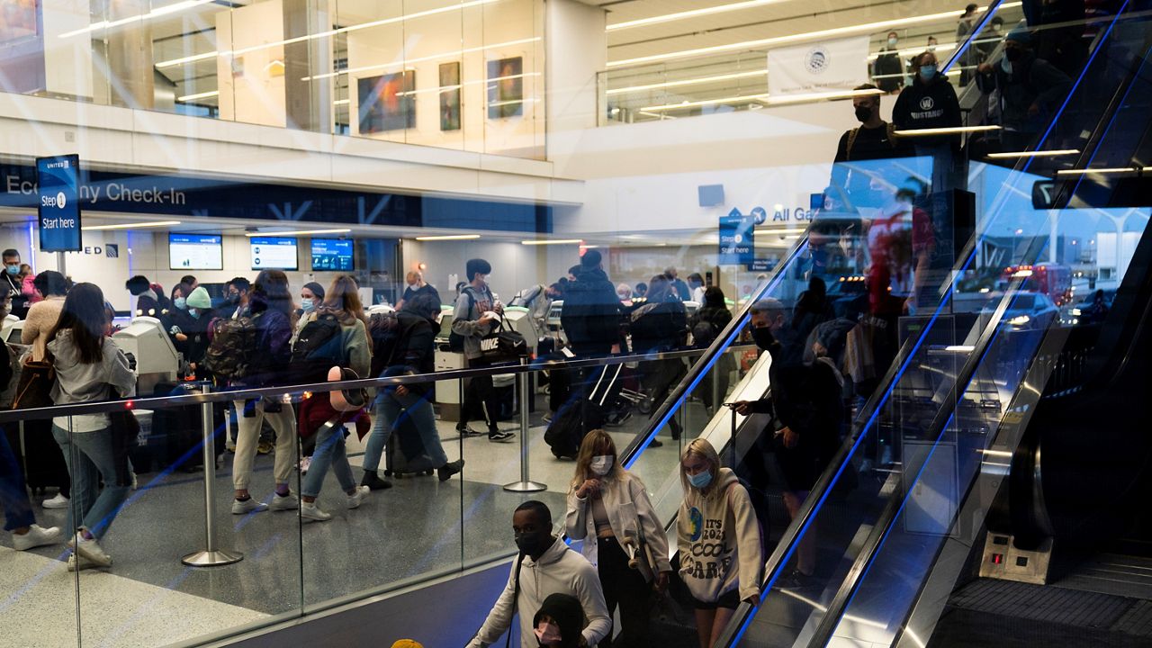 In this Nov. 24, 2021, file photo, travelers crowd the United Airlines check-in area at the Los Angeles International Airport in Los Angeles. (AP Photo/Jae C. Hong)