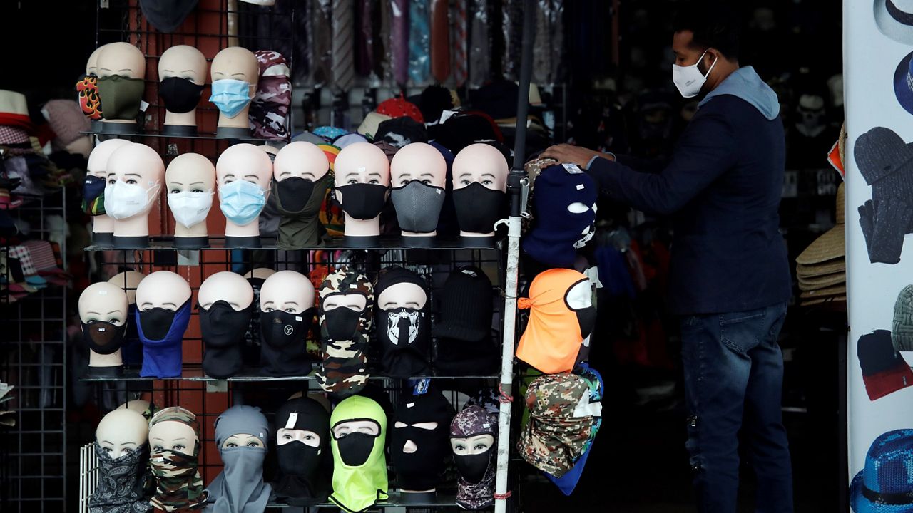 In this March 20, 2020, file photo, a merchant displays masks for sale in Los Angeles. (AP Photo/Marcio Jose Sanchez)