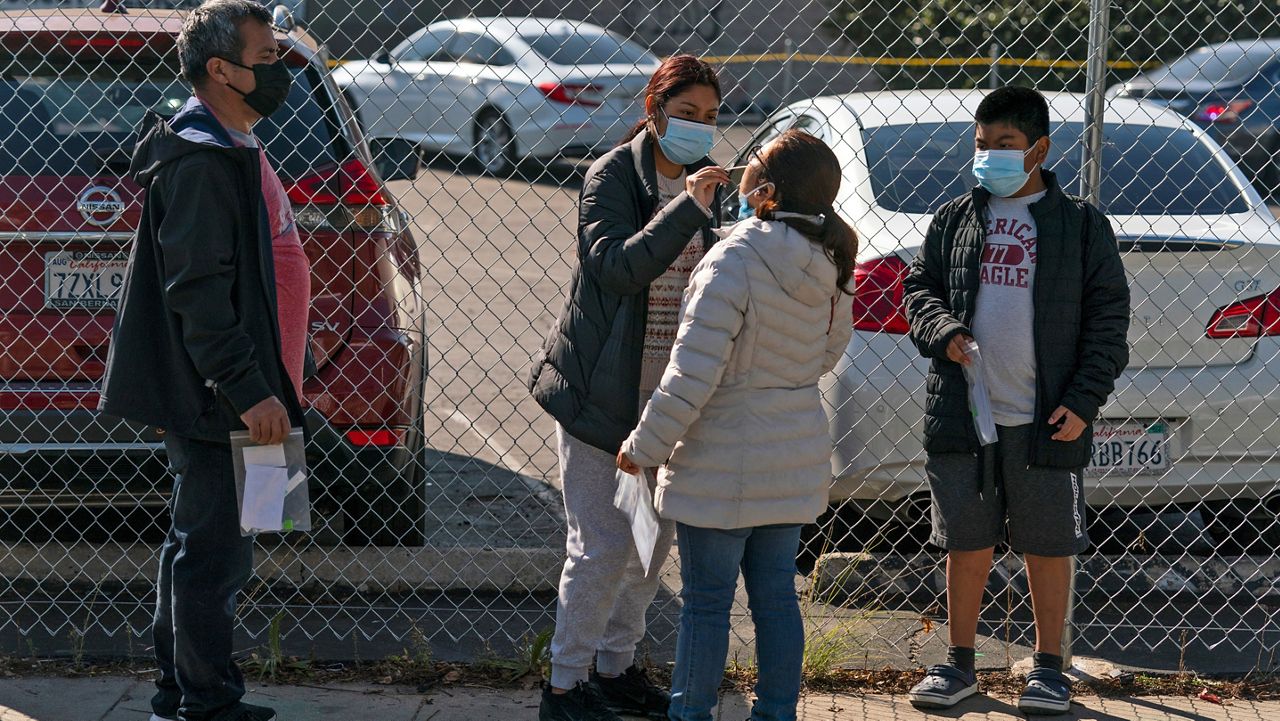 People take a COVID-19 test Tuesday at an outdoor testing site in Los Angeles. California is starting to feel the full wrath of the omicron variant. (AP Photo/Jae C. Hong)
