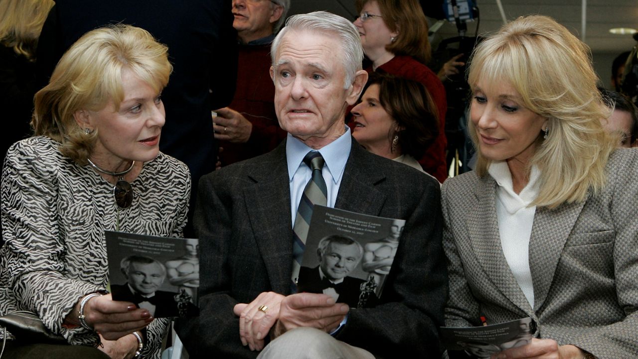 This Oct. 12, 2007, file photo, shows Dick Carson, the brother of entertainer Johnny Carson, center, Dick's wife Karlyn, left, and Johnny Carson's widow, Alex, holding programs before the dedication of the Johnny Carson school of film on the University of Nebraska Lincoln campus, in Lincoln, Nebraska. (AP Photo/Nati Harnik)