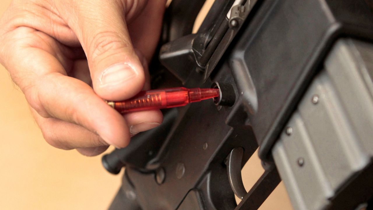 In this Aug. 15, 2012, file photo, a plastic replica of a bullet is used to quickly remove a magazine from an assault rifle in a demonstration at the California Department of Justice in Sacramento, Calif. (AP Photo/Rich Pedroncelli)