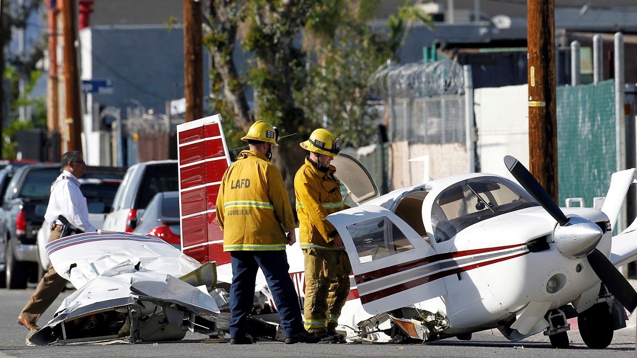 In this Feb. 22, 2016, file photo, Los Angeles city firefighters look at the wreckage of a small plane that crashed on approach to Whiteman Airport in the Pacoima area of Los Angeles' San Fernando Valley. (AP Photo/Nick Ut)