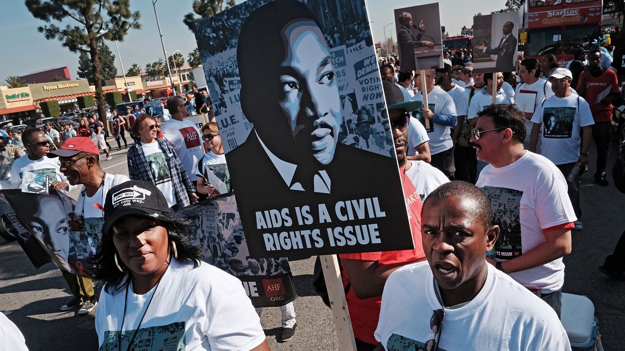 In this Jan. 19, 2015, file photo, participants carry signs as they march during the 30th annual Kingdom Day Parade in Los Angeles. (AP Photo/Richard Vogel)