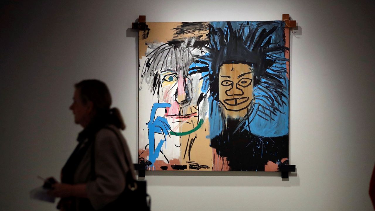 In this Sept. 20, 2017, file photo, the Jean-Michel Basquiat painting "Dos Cabezas," a portrait of Warhol and Basquiat, is displayed at the media view for "Basquiat: Boom for Real," the first large-scale exhibition in the UK of the work of American artist Jean-Michel Basquiat at the Barbican Art Gallery in London. (AP Photo/Matt Dunham)
