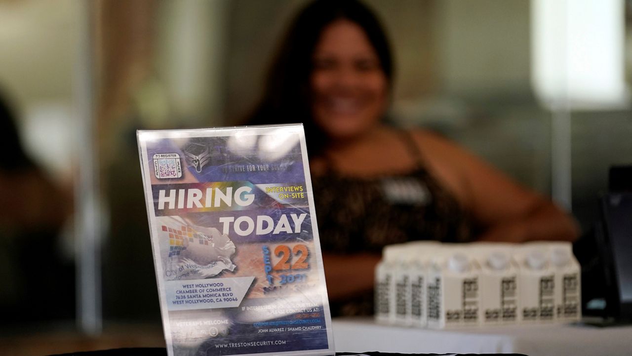 In this Sept. 22, 2001, file photo, a hiring sign is placed at a booth for prospective employers during a job fair in the West Hollywood section of Los Angeles. (AP Photo/Marcio Jose Sanchez)