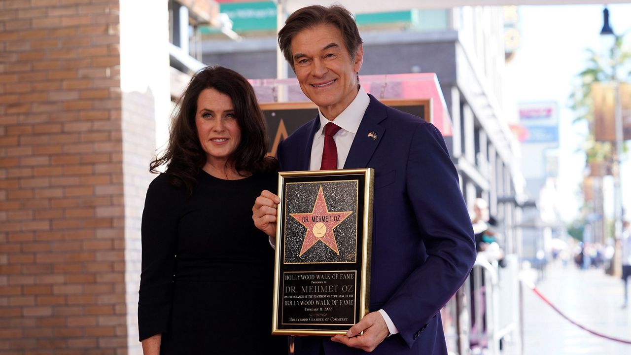 Mehmet Oz, the former host of “The Dr. Oz Show,” right, poses with his wife Lisa Oz as he holds a replica of his new star on the Hollywood Walk of Fame during a ceremony on Friday in Los Angeles. (AP Photo/Chris Pizzello)
