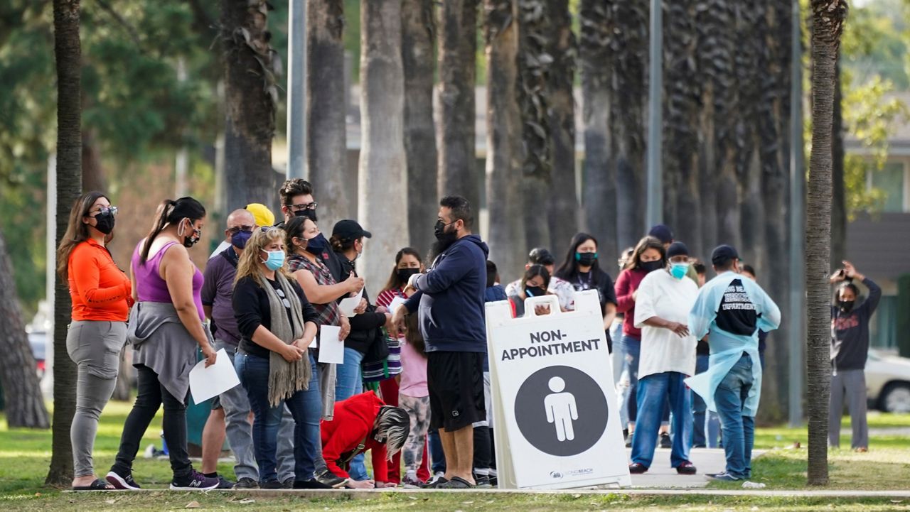 People wait in line to test for COVID-19 on Jan. 12, 2022, in Long Beach, Calif. (AP Photo/Ashley Landis)