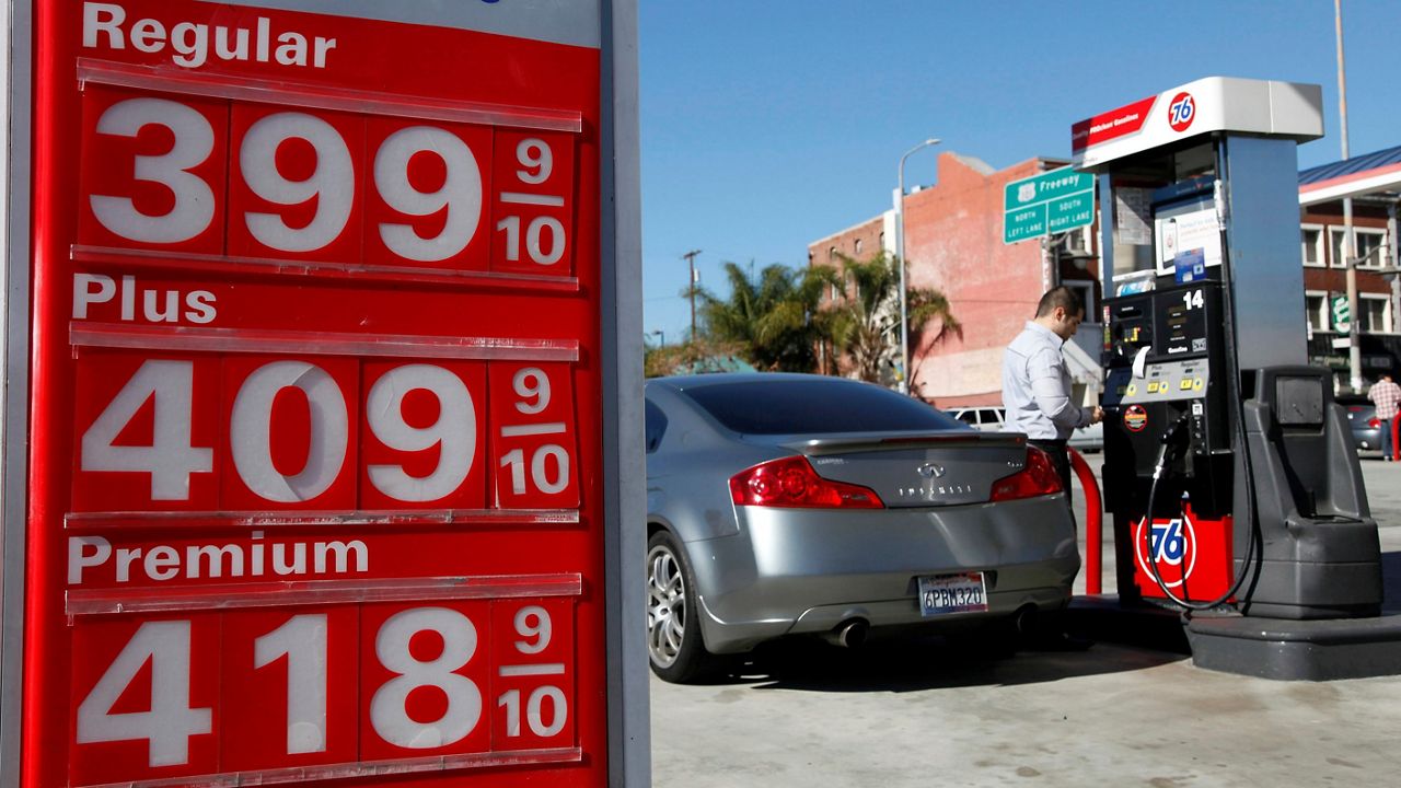 In this Jan. 31, 2013, file photo, a man buys gas at a station in Los Angeles. (AP Photo/Nick Ut)