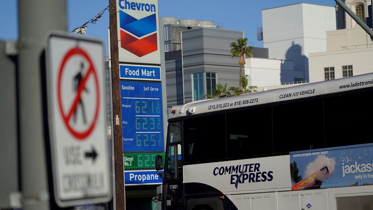 A clean air Commuter Express bus drives past a Chevron gas station Friday in downtown Los Angeles Friday. (AP Photo/Damian Dovarganes)
