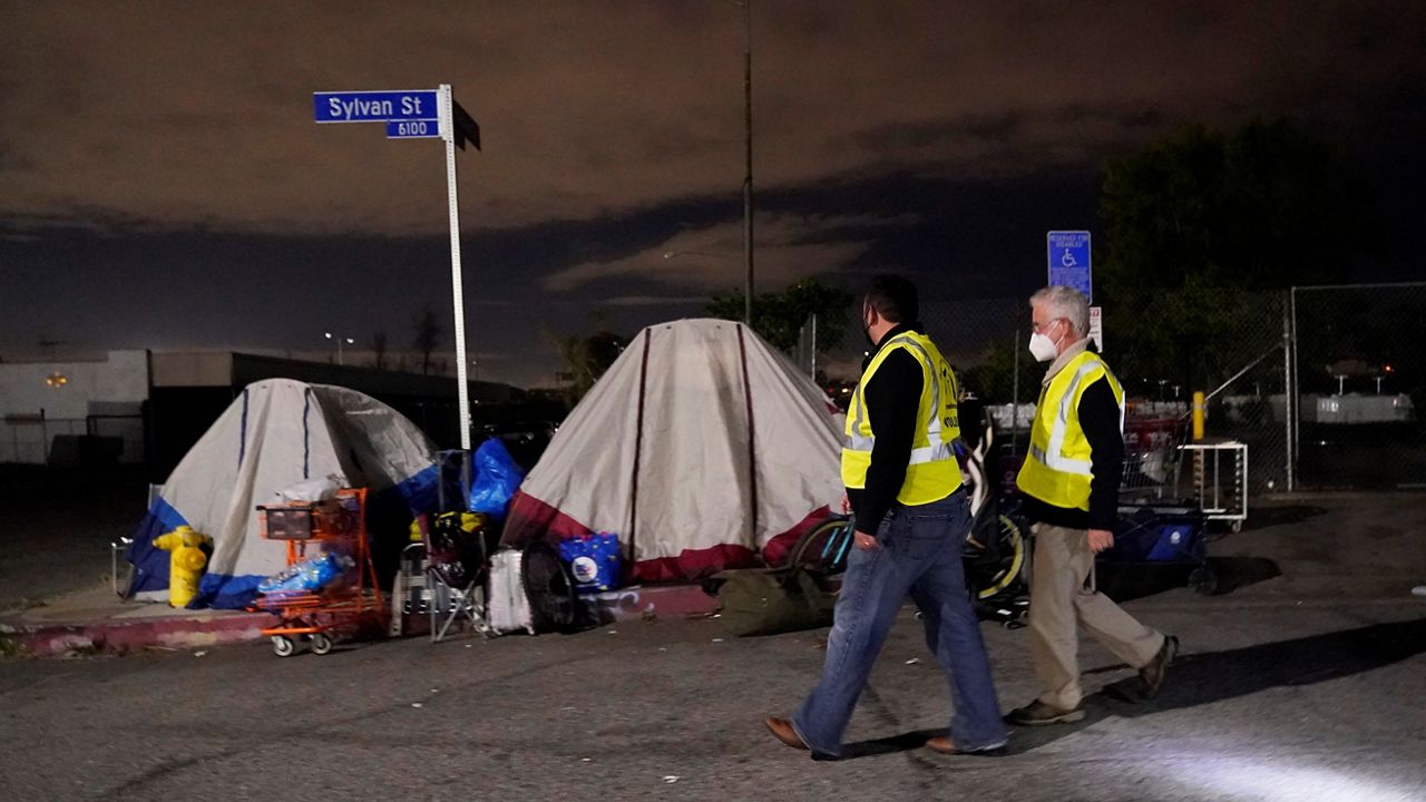 Los Angeles city councilmember Paul Krekorian, right, walks past tents where people are living as he walks with staff member Karo Torossian during an official homeless count Tuesday, Feb. 22, 2022, in the North Hollywood section of Los Angeles. Los Angeles County has resumed its annual homeless count in full a year after it was limited over concerns that it couldn't be done safely or accurately during the coronavirus pandemic. (AP Photo/Marcio Jose Sanchez)