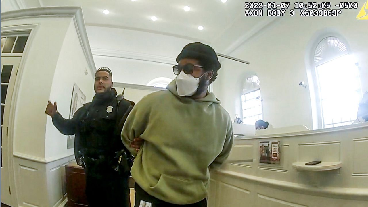 A police officer detains “Black Panther” director Ryan Coogler at a Bank of America branch in Atlanta, in this January 2022 image made from Atlanta Police video. Coogler was mistaken for a bank robber at the bank. (Atlanta Police Department via AP)