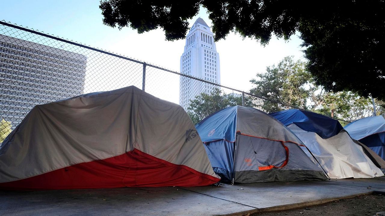 This July 1, 2019, file photo shows Los Angeles City Hall behind a homeless tent encampment along a street in downtown Los Angeles. (AP Photo/Richard Vogel)