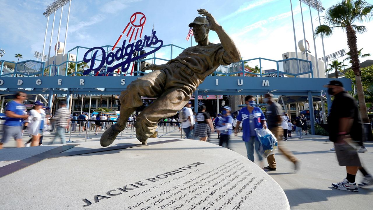 Fans walk by a statue of Jackie Robinson as they enter Dodger Stadium on June 15, 2021, prior to a baseball game between the Dodgers and the Philadelphia Phillies in Los Angeles. (AP Photo/Mark J. Terrill)