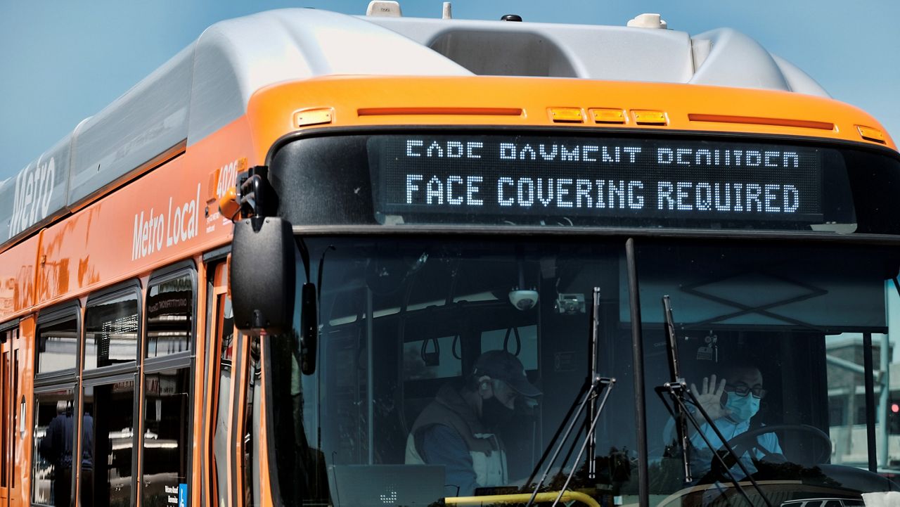 A Los Angeles Metro bus with an electronic display requiring a face mask is seen as the driver pulls out of a bus stop in Los Angeles on Tuesday, April 19, 2022. A federal judge's decision to strike down a national mask mandate was met with cheers on some airplanes but also concern about whether it's really time to end the order sparked by the COVID-19 pandemic. (AP Photo/Richard Vogel)