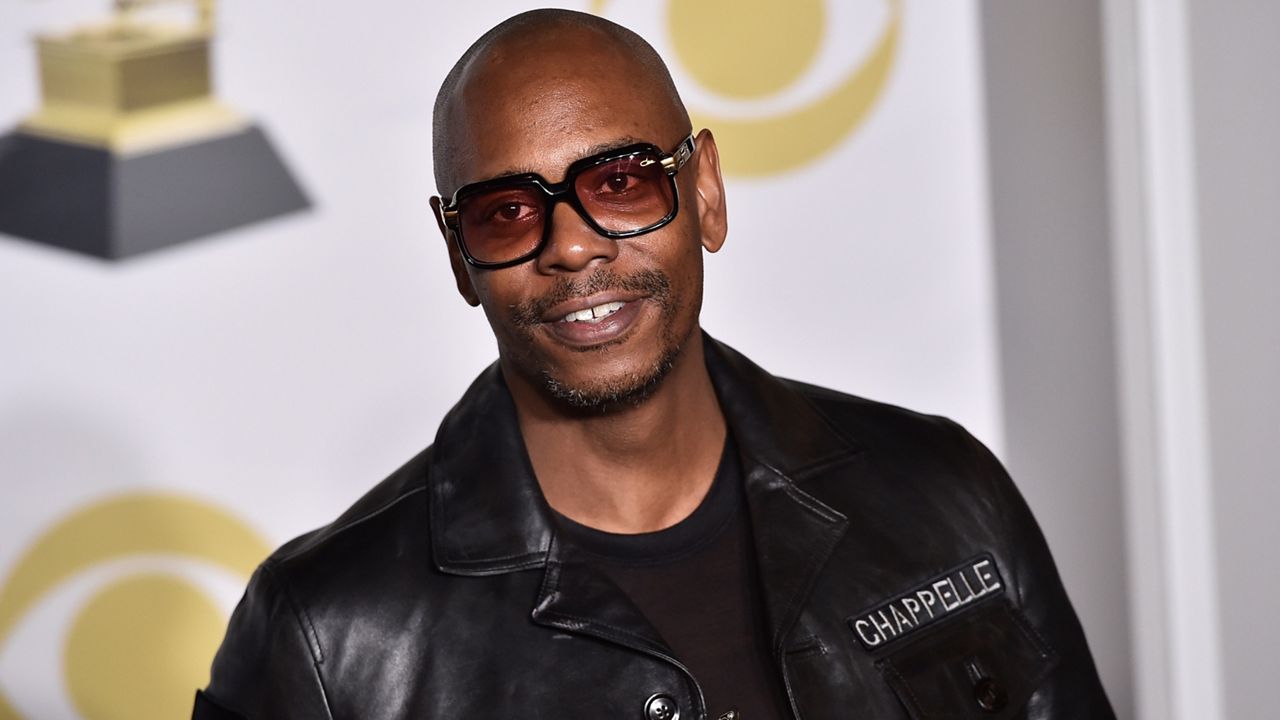 In this Jan. 28, 2018, file photo, Dave Chappelle poses in the press room with the best comedy album award for “The Age of Spin” and “Deep in the Heart of Texas” at the 60th annual Grammy Awards in New York. (Photo by Charles Sykes/Invision/AP)