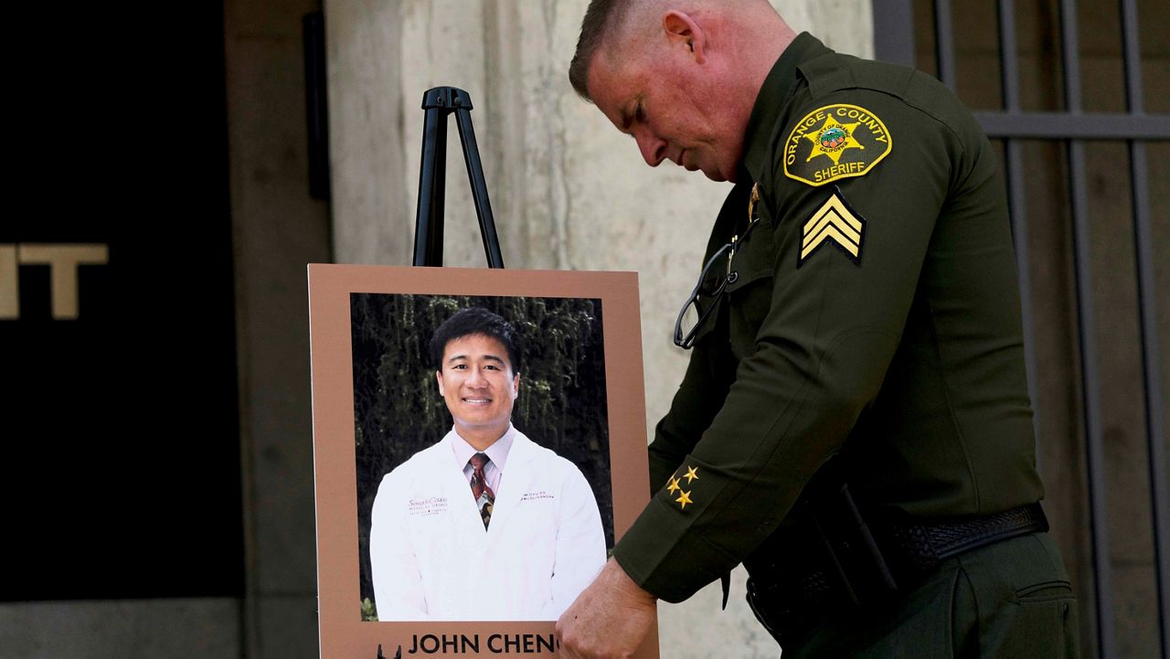 Orange County Sheriff’s Sgt. Scott Steinle displays a photo of Dr. John Cheng, a 52-year-old victim who was killed in Sunday’s shooting at Geneva Presbyterian Church, during a news conference Monday in Santa Ana, Calif. (AP Photo/Jae C. Hong)