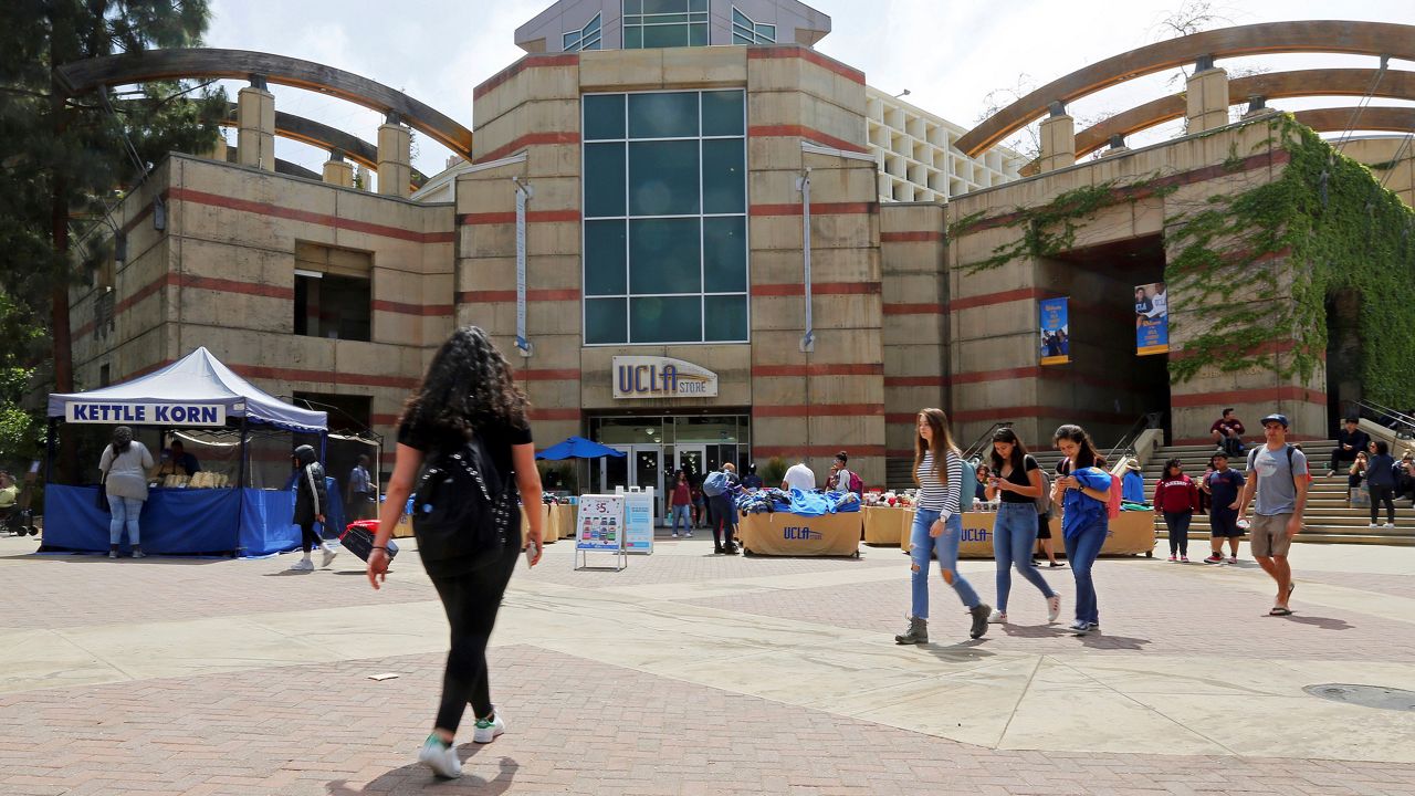 People pass Ackerman Student Union on the campus of the University of California, Los Angeles on April 26, 2019. (AP Photo/Reed Saxon)