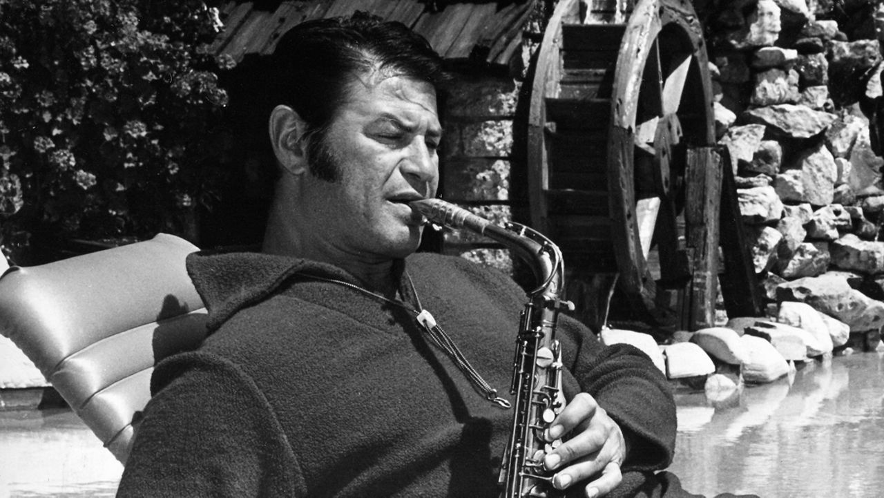 TV and motion picture star Larry Storch relaxes while playing a saxophone poolside at his Hollywood Hills, Calif., home in May 1966. (AP Photo)