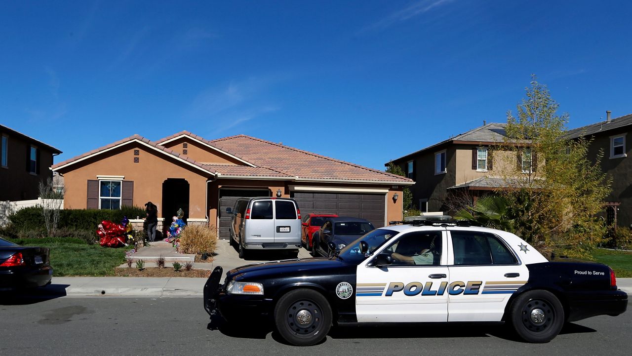 A police car drives past the home of David and Louise Turpin where police arrested the couple accused of holding 13 children captive on Jan. 24, 2018, in Perris, Calif. (AP Photo/Damian Dovarganes)