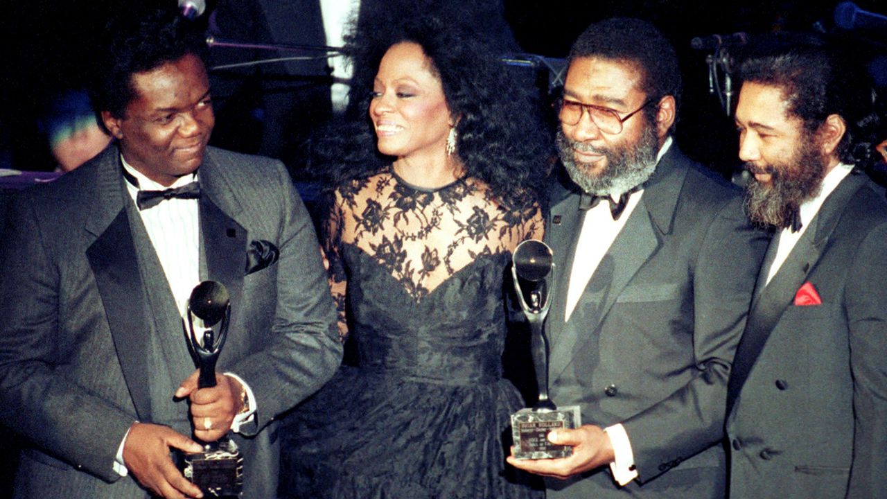 Singer Diana Ross, second from left, joins songwriters, from left, Lamont Dozier, Brian Holland and Eddie Holland after the writing team was inducted into the Rock and Roll Hall of Fame in New York on Jan. 17, 1990. (AP Photo/Ron Frehm)